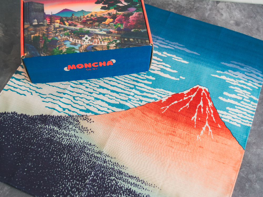 A Moncha box paired with a furoshiki cloth featuring Hokusai’s Red Fuji (Fine Wind, Clear Morning) — bringing a playful 