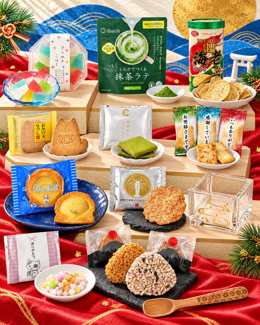 Ise box contents &mdash; Okagesama sweets, matcha latte, a clear masu cup and a wooden spoon on red silk